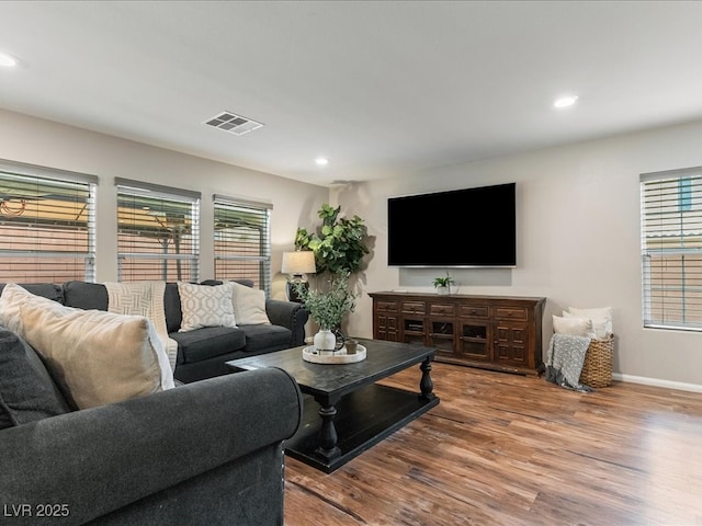 living room with plenty of natural light, visible vents, wood finished floors, and recessed lighting