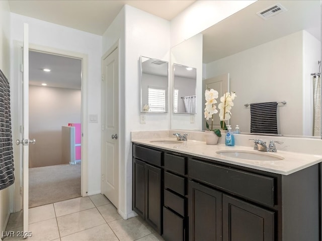 bathroom featuring double vanity, visible vents, a sink, and tile patterned floors