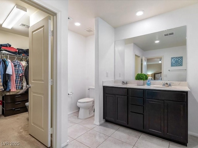 bathroom with toilet, visible vents, and a sink