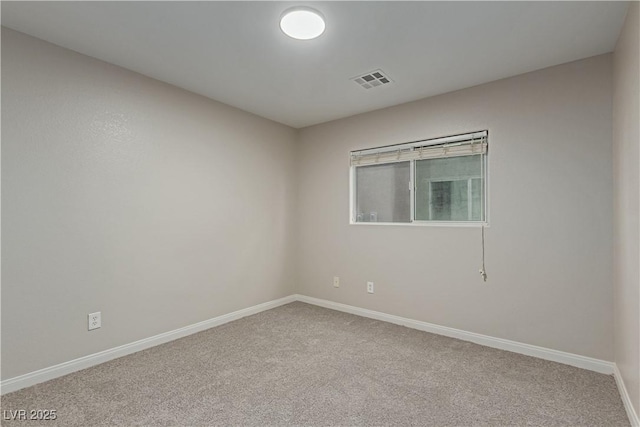 unfurnished room with carpet, visible vents, and baseboards