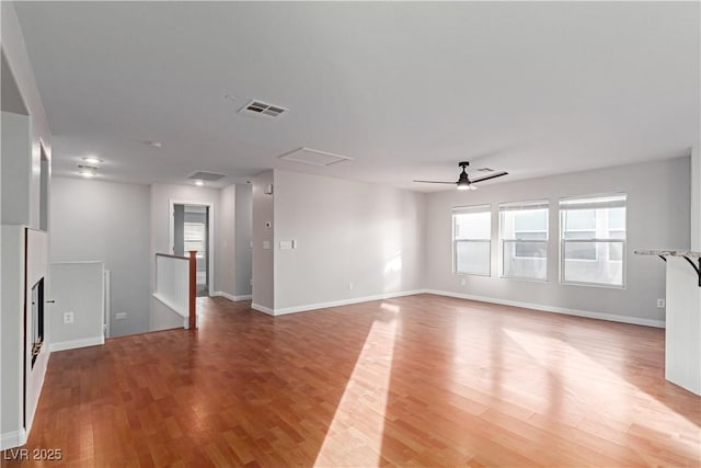 spare room featuring ceiling fan, visible vents, baseboards, light wood finished floors, and attic access