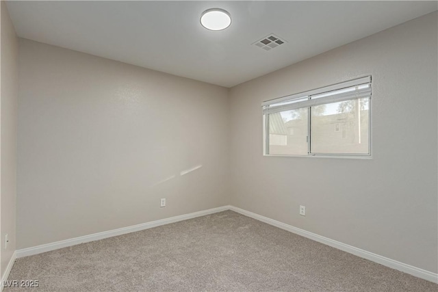 carpeted empty room with visible vents and baseboards