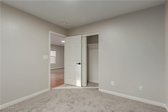 unfurnished bedroom featuring a closet, carpet, and baseboards