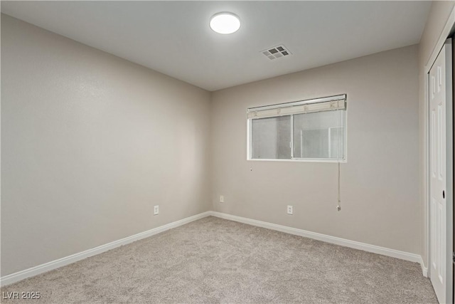 empty room with carpet, visible vents, and baseboards