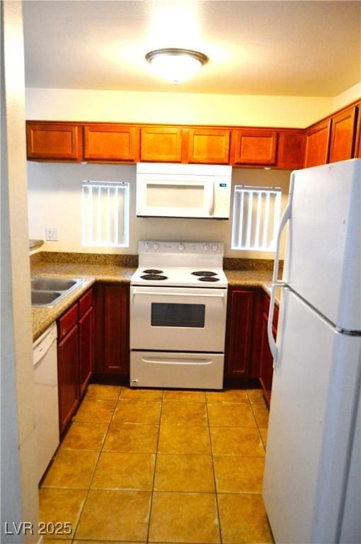 kitchen with white appliances, a sink, and light tile patterned floors