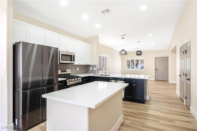 kitchen featuring light wood finished floors, visible vents, a kitchen island, appliances with stainless steel finishes, and light countertops