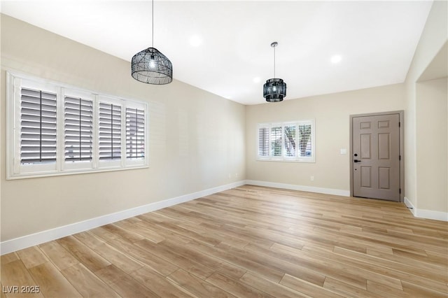 empty room with vaulted ceiling, recessed lighting, light wood-type flooring, and baseboards