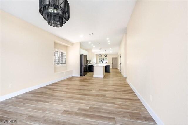 unfurnished living room with recessed lighting, light wood-type flooring, visible vents, and baseboards