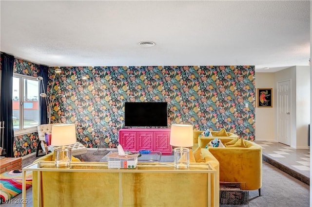 living area with wallpapered walls, visible vents, baseboards, and carpet flooring