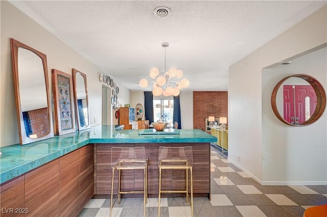 bar featuring light floors, baseboards, a textured ceiling, and an inviting chandelier