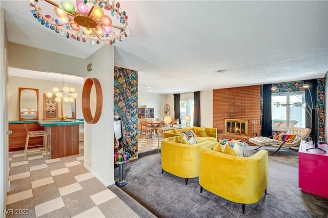 living room featuring a textured ceiling, baseboards, a brick fireplace, tile patterned floors, and an inviting chandelier