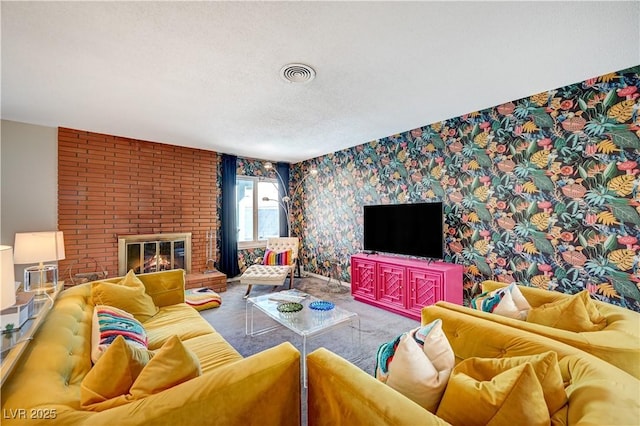 living room with wallpapered walls, visible vents, carpet, a textured ceiling, and a brick fireplace