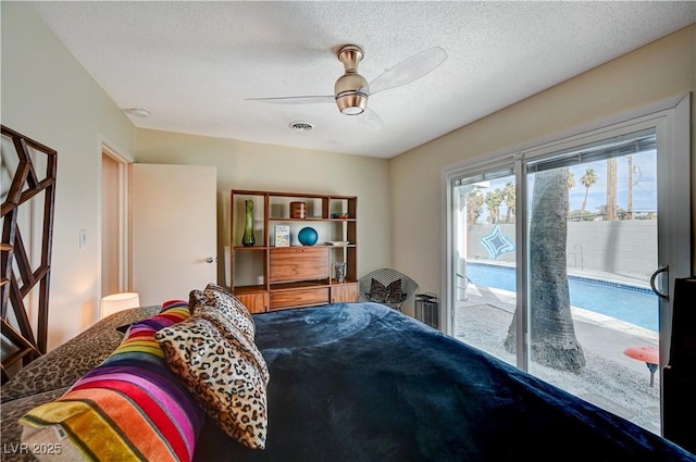 bedroom with a ceiling fan, access to outside, visible vents, and a textured ceiling