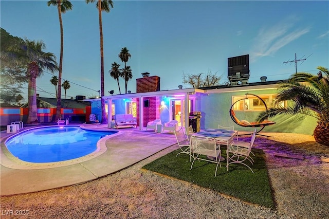 outdoor pool featuring a patio and central air condition unit