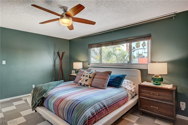 bedroom featuring baseboards, ceiling fan, a textured ceiling, and tile patterned floors