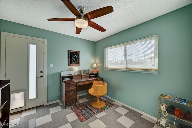 home office featuring a ceiling fan, baseboards, a textured ceiling, and tile patterned floors