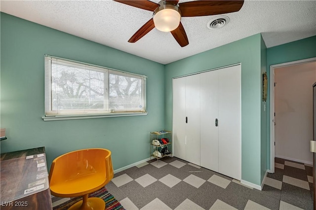 interior space featuring visible vents, a textured ceiling, baseboards, and tile patterned floors