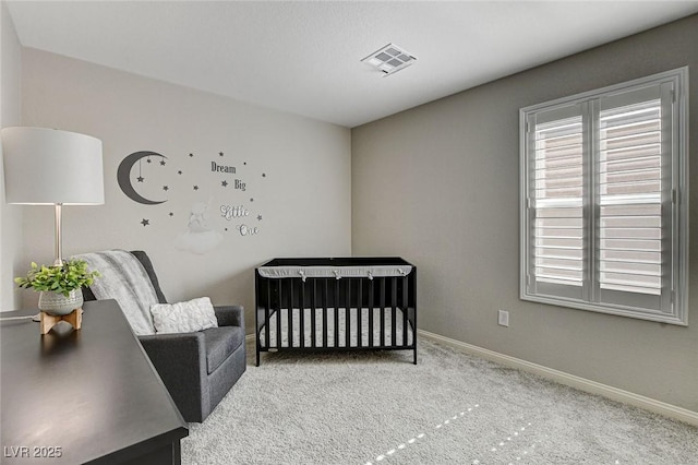 carpeted bedroom featuring a nursery area, visible vents, and baseboards