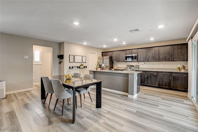 dining area with light wood-type flooring, baseboards, visible vents, and recessed lighting