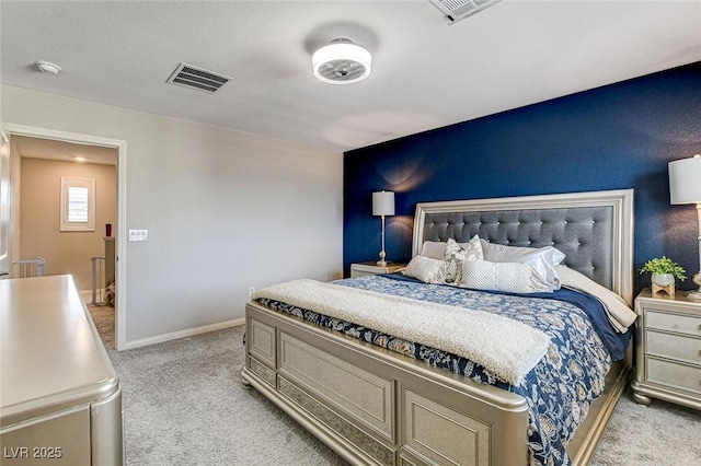 bedroom featuring visible vents, light carpet, and baseboards