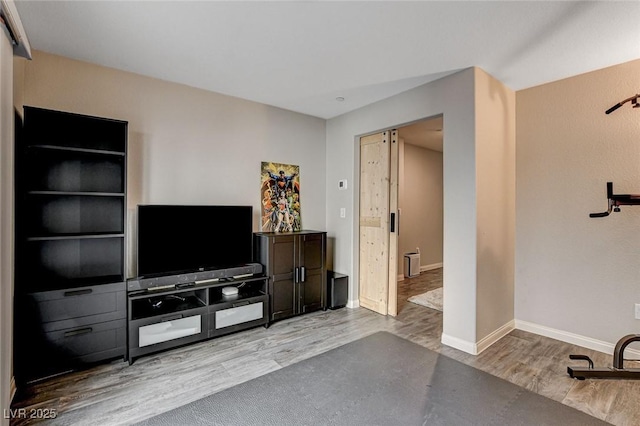 living area with baseboards and wood finished floors