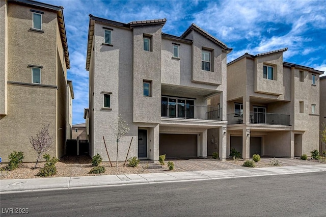 view of front of home with driveway, an attached garage, and stucco siding