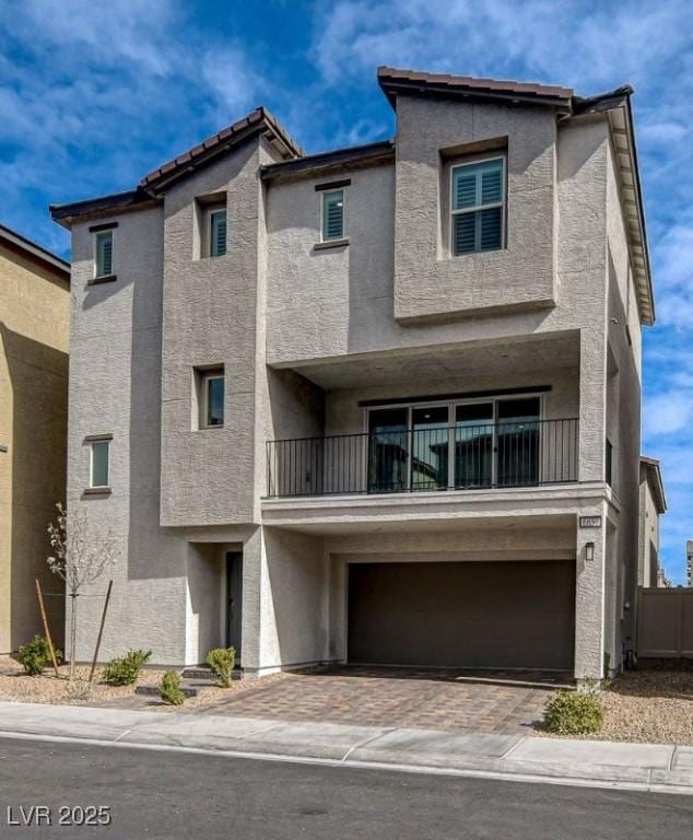 view of front of house featuring a garage, decorative driveway, and stucco siding