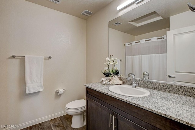 full bath featuring visible vents, toilet, vanity, wood finished floors, and baseboards