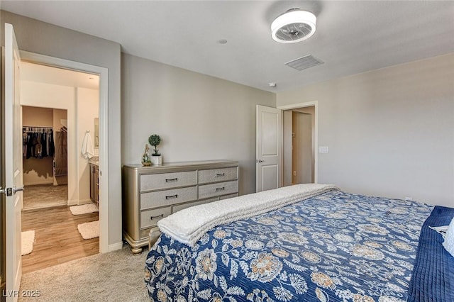 bedroom featuring baseboards, visible vents, and light colored carpet