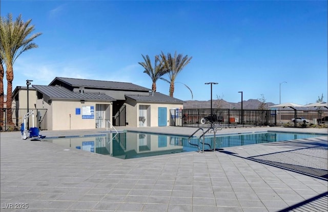 pool with fence, a mountain view, and a patio