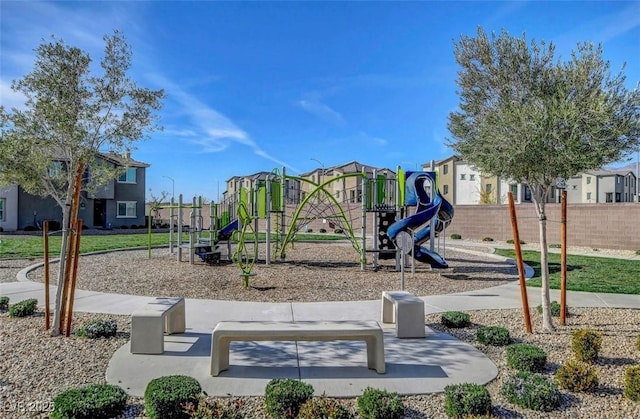 communal playground featuring a residential view and fence