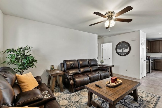 living area featuring a ceiling fan, baseboards, and light tile patterned floors