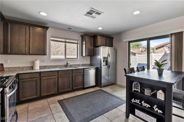 kitchen featuring visible vents, appliances with stainless steel finishes, dark brown cabinets, a sink, and recessed lighting