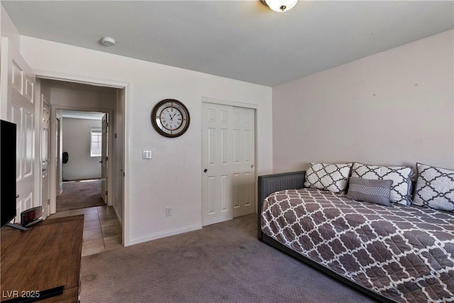 carpeted bedroom featuring baseboards and a closet