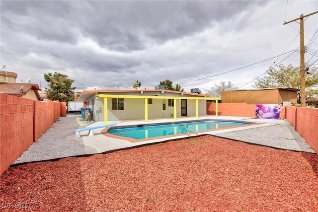 view of pool with a fenced in pool, a fenced backyard, a diving board, and a patio area