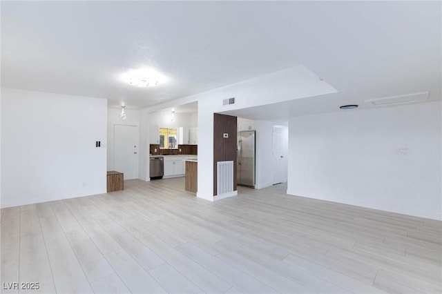 unfurnished living room with visible vents and light wood-style flooring