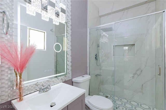 bathroom with toilet, a marble finish shower, and vanity