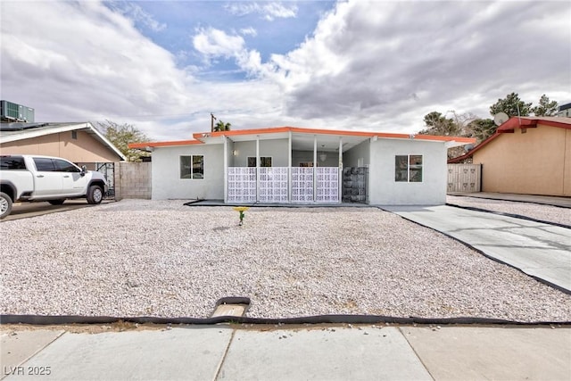 view of front of property featuring stucco siding and fence