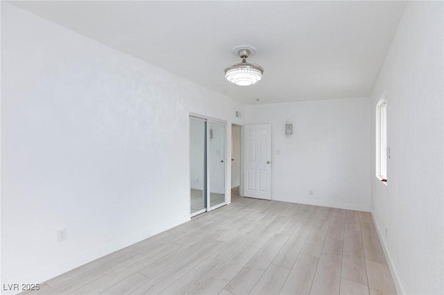unfurnished room with visible vents, baseboards, and light wood-style floors
