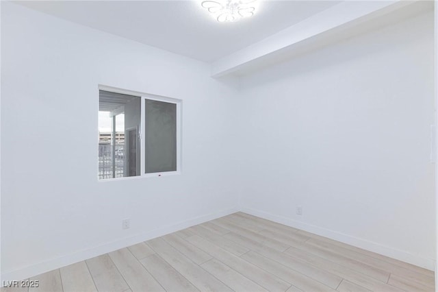 empty room with baseboards and light wood finished floors
