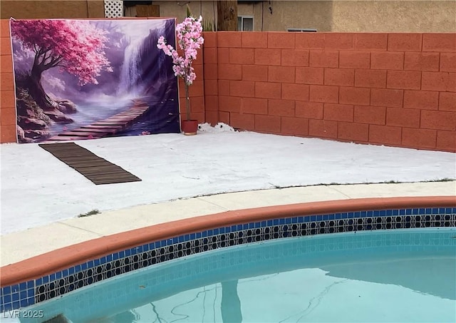 outdoor pool featuring fence