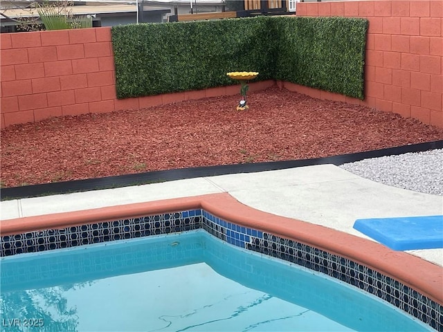 view of swimming pool featuring fence