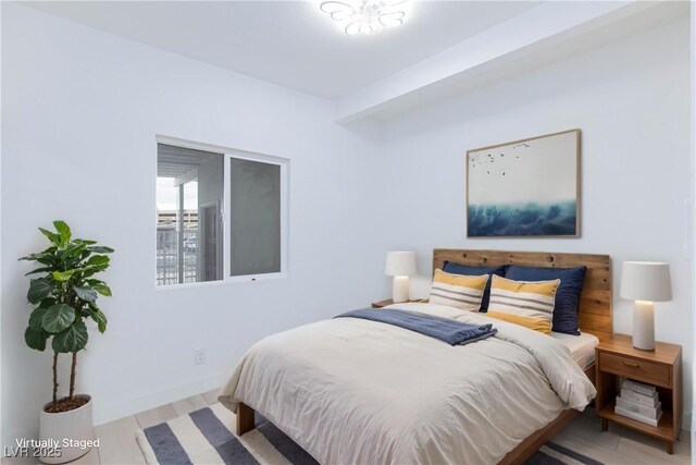 bedroom with baseboards and wood finished floors