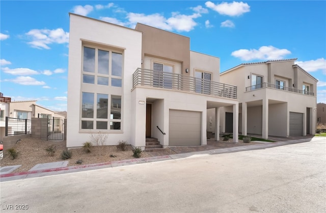 view of front of property featuring a balcony, an attached garage, and stucco siding