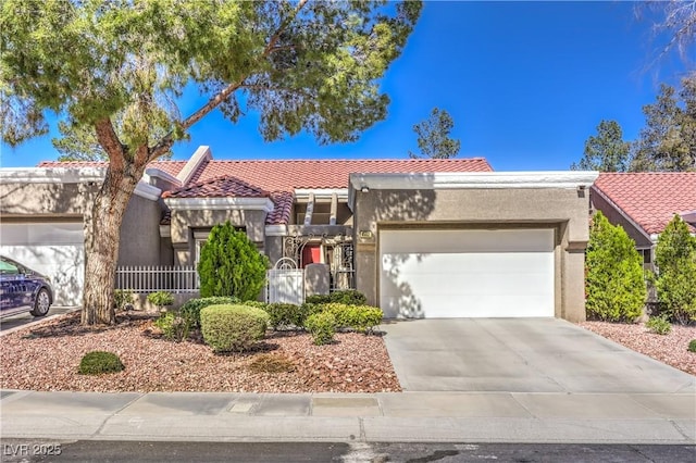 view of front of home featuring an attached garage, driveway, a tile roof, and stucco siding