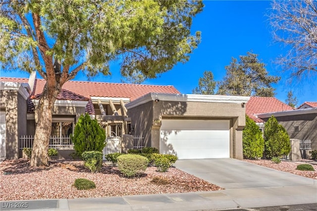 view of front of house featuring an attached garage, a tile roof, concrete driveway, and stucco siding