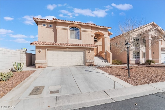 mediterranean / spanish-style home with a tile roof, stucco siding, an attached garage, fence, and driveway