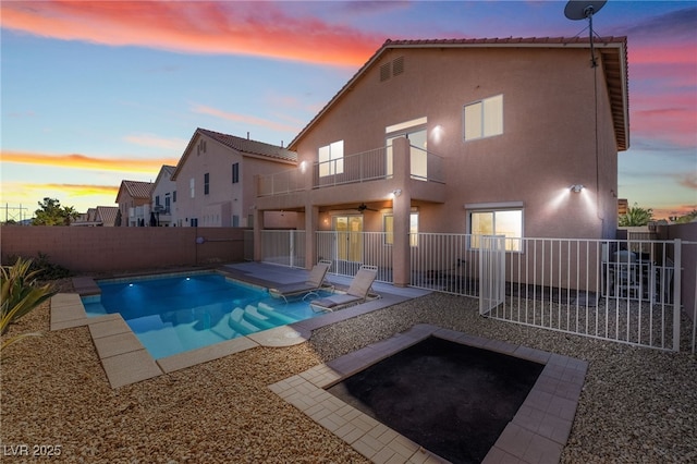 pool at dusk with a fenced in pool, a patio area, a fenced backyard, and ceiling fan