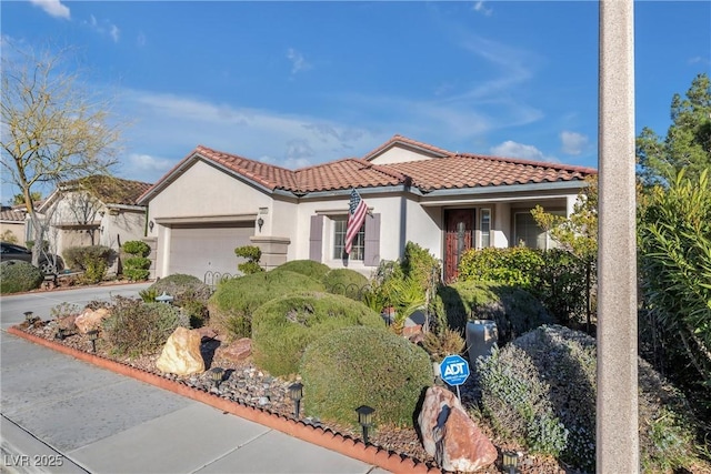 mediterranean / spanish-style home featuring a tile roof, driveway, an attached garage, and stucco siding