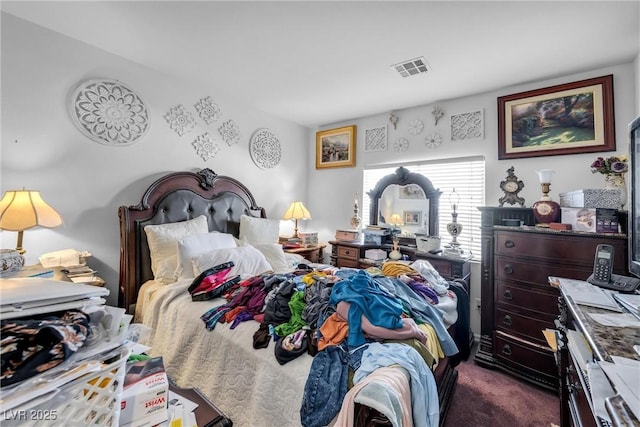 bedroom featuring dark colored carpet and visible vents